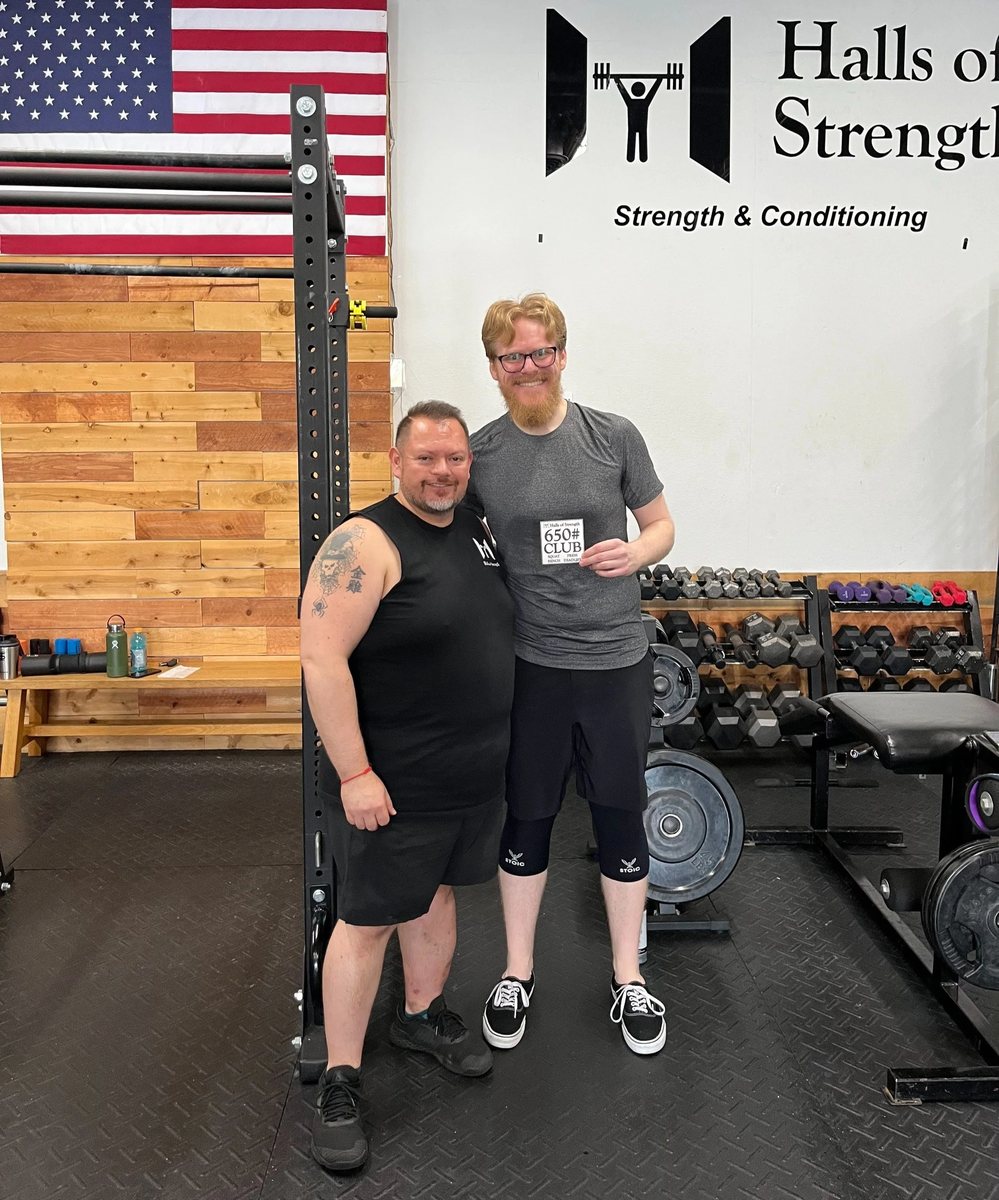 A coach and a member side by side on the floor at Halls of Strength